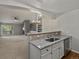 Open-concept dining area leading to kitchen with granite countertop and stainless steel dishwasher at 7131 S Wenatchee Way # C, Aurora, CO 80016