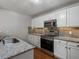 Updated kitchen with stainless steel appliances, granite countertops, and white cabinetry at 7131 S Wenatchee Way # C, Aurora, CO 80016