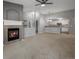 Open living room with fireplace, carpeted floors, and seamless flow into the kitchen at 7131 S Wenatchee Way # C, Aurora, CO 80016