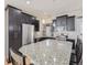 Granite-topped kitchen island with seating, stainless appliances, and white subway tile at 2514 Sweet Wind Ave, Castle Rock, CO 80109