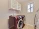 Convenient laundry room with modern washer and dryer units, ample shelving and natural light at 2514 Sweet Wind Ave, Castle Rock, CO 80109