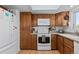 This kitchen features wood cabinets, a white refrigerator, a white range, and a microwave at 455 Saddlewood Cir, Highlands Ranch, CO 80126