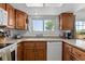 This kitchen offers a large window over the sink, light countertops, and wood cabinets at 455 Saddlewood Cir, Highlands Ranch, CO 80126