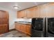 Well-equipped laundry room featuring modern washer and dryer, cabinets, and sink at 467 Saint Paul St, Denver, CO 80206