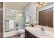 Bright bathroom featuring a shower-tub combo with sliding glass doors, a white sink, and ample lighting at 206 S 22Nd Ave, Brighton, CO 80601