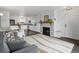 Cozy living room featuring a stone fireplace, plush rug, and an open view into the modern kitchen at 4226 S Eldridge St # 207, Morrison, CO 80465