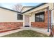 Inviting front porch featuring brick accents, wind chimes, and string lights at 3355 S Emerson St, Englewood, CO 80113
