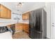 Modern kitchen with stainless steel appliances, wood cabinets, and tile backsplash at 3355 S Emerson St, Englewood, CO 80113