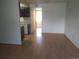 A spacious living room with laminate flooring extends to other rooms including the kitchen in the background at 10772 E Exposition Ave Ave # 342, Aurora, CO 80012