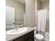 Well-maintained bathroom with sink, dark wood cabinet, and shower featuring a shower curtain at 15507 Quince Cir, Thornton, CO 80602