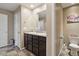 Bathroom with double sinks, dark wood cabinets, neutral walls, and a toilet in an adjacent room at 15507 Quince Cir, Thornton, CO 80602