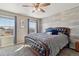 Bright bedroom features a ceiling fan, two windows, and a wood-paneled accent wall behind a large bed at 15507 Quince Cir, Thornton, CO 80602