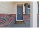 Welcoming front door with classic brick surround and stylish light fixture at 15507 Quince Cir, Thornton, CO 80602
