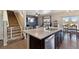Open-concept kitchen with a large island, stainless steel appliances, and a view of the living area at 15507 Quince Cir, Thornton, CO 80602