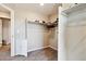 Functional walk-in closet features shelving for shoes, clothing rods, and neutral carpet flooring at 15507 Quince Cir, Thornton, CO 80602