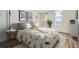 Bright bedroom featuring large bed with feather-patterned comforter, patterned pillows, and modern art on the walls at 601 W 11Th Ave # 815, Denver, CO 80204