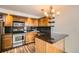 Well-lit kitchen with wood cabinets, granite countertops, stainless steel appliances, and hardwood floors at 601 W 11Th Ave # 815, Denver, CO 80204