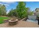 Outdoor patio featuring a stone fire pit and hot tub with mature landscaping and a wooden fence at 24682 E Ontario Dr, Aurora, CO 80016