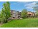 Beautiful backyard with a lush lawn, stone patio and outdoor dining area for entertaining at 24682 E Ontario Dr, Aurora, CO 80016