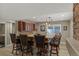 Basement bar area with seating, stone accents, dark wood cabinets, and modern pendant lighting at 24682 E Ontario Dr, Aurora, CO 80016