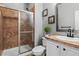 Bathroom with tiled shower, modern vanity, and decorative wall art at 24682 E Ontario Dr, Aurora, CO 80016