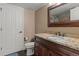 Bathroom featuring a dark wood vanity with granite countertop, a mirror, and a shower at 24682 E Ontario Dr, Aurora, CO 80016