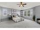 This primary bedroom features a trey ceiling, neutral tones, and bright natural light from the large shuttered windows at 24682 E Ontario Dr, Aurora, CO 80016