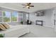 Bright primary bedroom with three windows, a ceiling fan and decorative light fixture, and sitting area at 24682 E Ontario Dr, Aurora, CO 80016