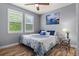 Cozy bedroom featuring wood floors, shuttered windows, and a queen-sized bed with blue accents at 24682 E Ontario Dr, Aurora, CO 80016