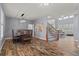 Open dining room with modern chandelier and wood table next to staircase and hallway at 24682 E Ontario Dr, Aurora, CO 80016