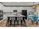 Modern kitchen with white cabinets, black appliances, island with seating, and dining area at 24682 E Ontario Dr, Aurora, CO 80016