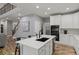 Open kitchen with white cabinets, island with black sink, and stairs to the second level at 24682 E Ontario Dr, Aurora, CO 80016