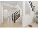 Open-concept foyer featuring elegant wood floors, staircase with dark wood railing, and white trim at 16345 Milwaukee St, Thornton, CO 80602