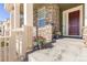 Inviting front porch enhanced by stone accents, decorative plants, and a stylish front door at 16345 Milwaukee St, Thornton, CO 80602