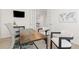 Spacious home office featuring modern desk, two chairs, and a view into the kitchen through french doors at 16345 Milwaukee St, Thornton, CO 80602