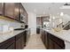 Well-equipped kitchen with stainless steel appliances, a granite island, and dark wood cabinetry at 16345 Milwaukee St, Thornton, CO 80602