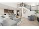 Inviting living room with a gray sectional couch, wood floors, and a staircase at 16345 Milwaukee St, Thornton, CO 80602