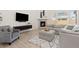 Cozy living room with a modern fireplace, vaulted ceilings, gray furnishings, and wood floors at 16345 Milwaukee St, Thornton, CO 80602