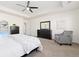 Spacious primary bedroom with tray ceilings, a gray armchair, and ample closet space at 16345 Milwaukee St, Thornton, CO 80602