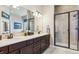 Bathroom showcasing a large mirror, and sinks and a walk in shower with glass door at 438 Galaxy Dr, Castle Rock, CO 80108