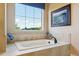 A soaking tub next to a window with tile surround and view to the outside at 438 Galaxy Dr, Castle Rock, CO 80108