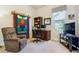 Cozy bedroom with brown carpet featuring a wooden desk, comfy chair, and large window for natural light at 438 Galaxy Dr, Castle Rock, CO 80108