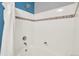 Bright bathroom featuring tiled walls and a shower with decorative accent tiles at 7440 S Blackhawk St # 16-208, Englewood, CO 80112