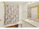 Well-lit bathroom with a vanity, mirror, and shower featuring a decorative shower curtain at 7440 S Blackhawk St # 16-208, Englewood, CO 80112