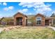 Beautiful home exterior with a stone archway entrance, well-maintained landscaping, and a lush lawn at 7440 S Blackhawk St # 16-208, Englewood, CO 80112