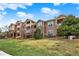 Condominium buildings showcasing balconies, stone accents, and vibrant green lawns at 7440 S Blackhawk St # 16-208, Englewood, CO 80112