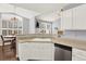 Kitchen with white cabinets, a stainless steel dishwasher, and eat-in dining space at 7440 S Blackhawk St # 16-208, Englewood, CO 80112