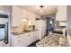 Well-lit kitchen featuring granite countertops, modern appliances, and white cabinets at 2531 S Hoyt Ct, Lakewood, CO 80227