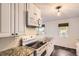 Charming kitchen with white cabinets, granite counters, and modern oven at 2531 S Hoyt Ct, Lakewood, CO 80227