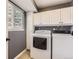 Laundry room with washer, dryer, cabinets, and a window that provides natural light at 2531 S Hoyt Ct, Lakewood, CO 80227